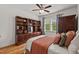 Inviting bedroom boasts beautiful built-in shelving, hardwood floors, and natural light from a bright window at 563 Great Ridge Parkway, Chapel Hill, NC 27516