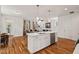 Open kitchen and living space with hardwood floors, pendant lights, and natural light at 563 Great Ridge Parkway, Chapel Hill, NC 27516