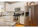 Kitchen featuring stainless steel appliances, granite countertops, and white cabinets at 5710 Corbon Crest Ln, Raleigh, NC 27612