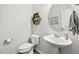 Clean powder room with a pedestal sink, modern fixtures, and neutral decor at 575 Dawley Dr, Fuquay Varina, NC 27526