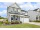 Charming two-story home with gray siding, stone accents, and a welcoming front porch with lush landscaping at 575 Dawley Dr, Fuquay Varina, NC 27526