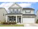 Charming two-story home with a welcoming front porch, gray siding, and stone accents at 575 Dawley Dr, Fuquay Varina, NC 27526