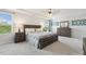 Bright main bedroom featuring tray ceilings, a ceiling fan, and natural light from large windows at 575 Dawley Dr, Fuquay Varina, NC 27526