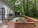 Spacious wooden back deck surrounded by lush trees and seasonal flowers at 5817 Wintergreen Dr, Raleigh, NC 27609
