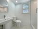 Bright bathroom with modern sink, toilet, and a tiled shower with glass door at 5817 Wintergreen Dr, Raleigh, NC 27609