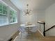 Cozy dining area with modern lighting, board and batten wall, and a large window overlooking the yard at 5817 Wintergreen Dr, Raleigh, NC 27609
