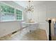 Dining room with a modern light fixture, bright natural light from the window, and stylish chairs at 5817 Wintergreen Dr, Raleigh, NC 27609