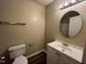 Neutral bathroom showcasing a single sink vanity, round mirror, and toilet at 620 Hanska Way, Raleigh, NC 27610