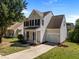 Two-story home with light yellow siding, black shutters, and an attached garage at 620 Hanska Way, Raleigh, NC 27610