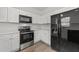 Modern kitchen with black appliances, light wood floors, and white cabinets at 620 Hanska Way, Raleigh, NC 27610