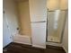 Bathroom showcasing a combination tub and shower with glass doors and wooden-look flooring at 633 Prickly Pear Dr, Fuquay Varina, NC 27526