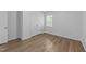Bright bedroom featuring wood-look floors, natural light, and double-door closet at 633 Prickly Pear Dr, Fuquay Varina, NC 27526