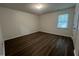 Clean bedroom with wood-look flooring, light walls, one window, and standard lighting fixture at 633 Prickly Pear Dr, Fuquay Varina, NC 27526