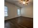 Bright bedroom featuring wood-look floors, a ceiling fan, and two large windows at 633 Prickly Pear Dr, Fuquay Varina, NC 27526