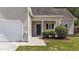 Front door with landscaped bushes, with an attached garage and a small overhang at 633 Prickly Pear Dr, Fuquay Varina, NC 27526