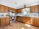 Well-lit kitchen featuring stainless steel appliances, wood cabinets, and wood flooring at 6718 Twin Tree Ct, Raleigh, NC 27613