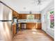 Well-lit kitchen with stainless steel appliances, hardwood floors, and wooden cabinets at 6718 Twin Tree Ct, Raleigh, NC 27613