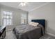 Bedroom featuring a bed with a blue padded headboard, and two windows that provide natural light at 703 Kirkeenan Cir, Morrisville, NC 27560