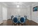 Elegant dining room featuring a modern chandelier and a glass-top table with blue chairs at 703 Kirkeenan Cir, Morrisville, NC 27560