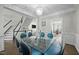 Bright dining room with glass table and modern chandelier, adjacent to staircase and living areas at 703 Kirkeenan Cir, Morrisville, NC 27560