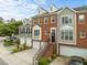 Attractive brick townhome featuring a two-car garage, landscaped front, and an inviting entryway staircase at 703 Kirkeenan Cir, Morrisville, NC 27560