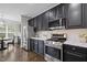 Beautiful kitchen featuring stainless steel appliances, white countertops, and black cabinets at 703 Kirkeenan Cir, Morrisville, NC 27560