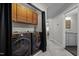 Convenient laundry area with black Samsung washer and dryer, along with practical overhead cabinets at 703 Kirkeenan Cir, Morrisville, NC 27560