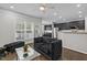 Stylish living room with dark sofa, modern decor, and an open layout to the kitchen at 703 Kirkeenan Cir, Morrisville, NC 27560