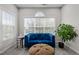 Bright sitting area featuring a blue velvet sofa, decorative ottoman, and a large window at 703 Kirkeenan Cir, Morrisville, NC 27560