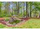 Secluded backyard features a tranquil pond with small waterfall feature and a bench to relax and enjoy the scenery at 7321 Clarincarde Ct, Wake Forest, NC 27587