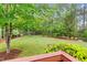A spacious backyard with lots of greenery, a trampoline and a fire pit at 7321 Clarincarde Ct, Wake Forest, NC 27587