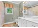 Bright bathroom with double sink vanity, framed mirror, white cabinets, and shower with patterned curtain at 7321 Clarincarde Ct, Wake Forest, NC 27587