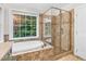 Luxury bathroom featuring soaking tub, tiled shower and a large sunny window at 7321 Clarincarde Ct, Wake Forest, NC 27587
