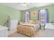 Cozy bedroom with a metal bed frame, plush bedding, and soft, natural light from the double windows at 7321 Clarincarde Ct, Wake Forest, NC 27587