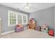 ' bedroom featuring a window, hardwood floors, neutral walls, dollhouse, and storage bench at 7321 Clarincarde Ct, Wake Forest, NC 27587