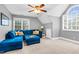 Cozy bonus room featuring a blue sectional couch, ceiling fan and neutral walls at 7321 Clarincarde Ct, Wake Forest, NC 27587