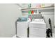 Functional laundry area with a washer, dryer, storage shelves, and cleaning supplies for convenience at 7321 Clarincarde Ct, Wake Forest, NC 27587