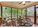 Relaxing screened porch with outdoor furniture, wood flooring, ceiling fan, and views of the wooded backyard at 7321 Clarincarde Ct, Wake Forest, NC 27587