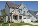 Charming home featuring stonework, a two-car garage, and manicured lawn under clear blue skies at 737 W Holly Springs Rd, Holly Springs, NC 27540