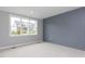 Bedroom with neutral carpet, blue accent wall, and a large window at 743 W Holly Springs Rd, Holly Springs, NC 27540