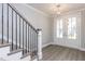 Bright entryway showcasing beautiful flooring, contemporary lighting, and a staircase at 743 W Holly Springs Rd, Holly Springs, NC 27540