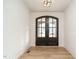The bright foyer features an arched glass double-door entry and light wood flooring at 749 W Holly Springs Rd, Holly Springs, NC 27540