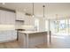 The open kitchen features a kitchen island, modern lighting, and stainless appliances at 749 W Holly Springs Rd, Holly Springs, NC 27540
