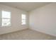 A bright, carpeted bedroom with two windows offering ample natural light at 755 W Holly Springs Rd, Holly Springs, NC 27540