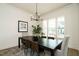 Bright dining room with a dark wood table, contemporary chandelier, and large windows at 755 W Holly Springs Rd, Holly Springs, NC 27540