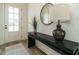 Inviting entryway featuring a stylish console table, round mirror, and a bright doorway at 755 W Holly Springs Rd, Holly Springs, NC 27540