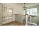 Upstairs hallway featuring hardwood floors, natural lighting and adjacent french doors at 755 W Holly Springs Rd, Holly Springs, NC 27540