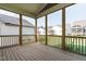 Enjoy outdoor living on this screened-in porch with wooden decking and views of neighboring homes at 761 W Holly Springs Rd, Holly Springs, NC 27540