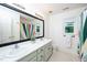 Bright bathroom with double sinks, a large mirror, and a shower/tub with colorful curtain accents at 8009 Tobin Pl, Raleigh, NC 27612