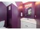 This stylish bathroom features a modern vanity with a sleek mirror and vibrant purple walls at 8009 Tobin Pl, Raleigh, NC 27612